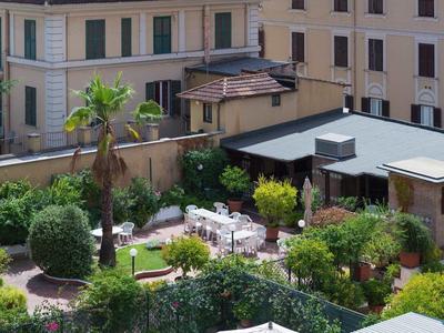 Hotel courtyard with garden, seating areas, and surrounding buildings.