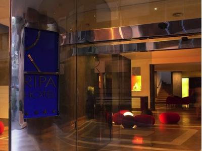 Ein halb geöffneter Glastürbogen führt in einen modernen, warm beleuchteten Innenraum.