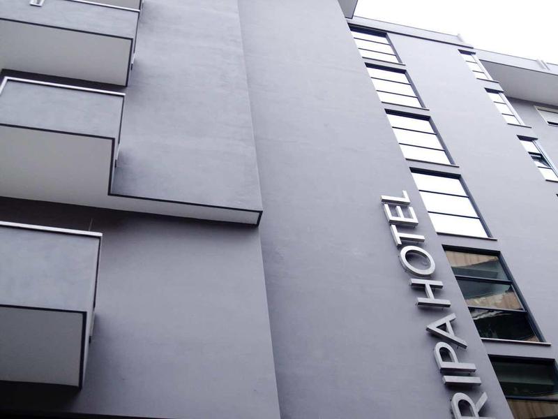 Mehrstöckiges graues Hotelgebäude mit großen Fenstern und vertikalem Schriftzug "RIPAFLOTE".