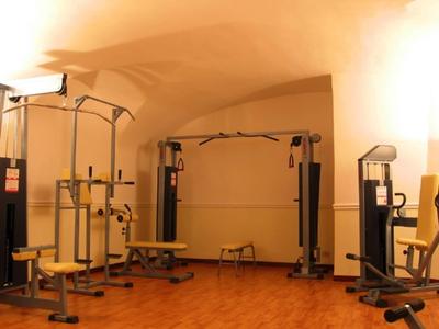 Ein Fitnessraum mit verschiedenen Trainingsgeräten unter einer gewölbten Decke.