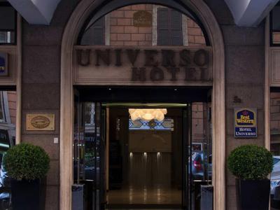 Eingang zu einem Hotel mit Bogen und Blumendekoration an den Seiten.