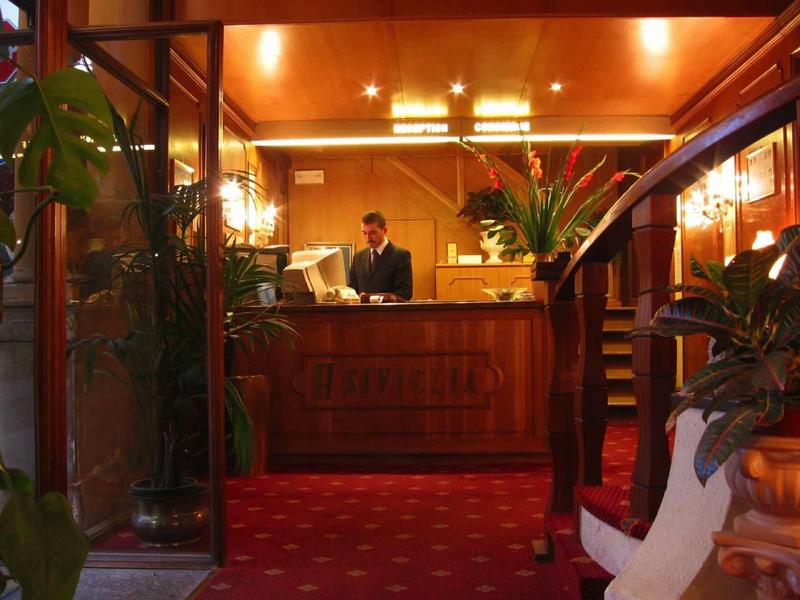 Hotelreceptie met conciërge achter de balie in een gezellige sfeer.