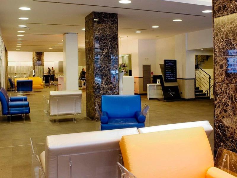 Moderne Lobby mit bunten Sesseln, Marmorsäulen und hellem, großzügigem Raumdesign.