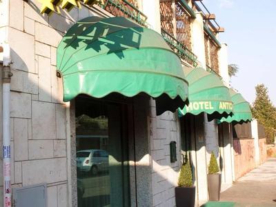 Facciata di un hotel con tende verdi e insegna con quattro stelle.