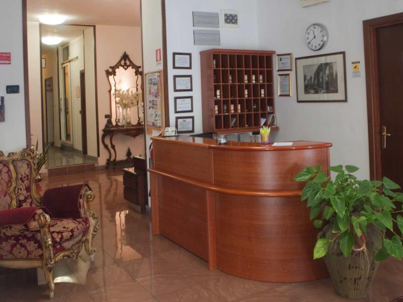 Elegantní hotelová recepce s dřevěnou přepážkou, křesly a rostlinami