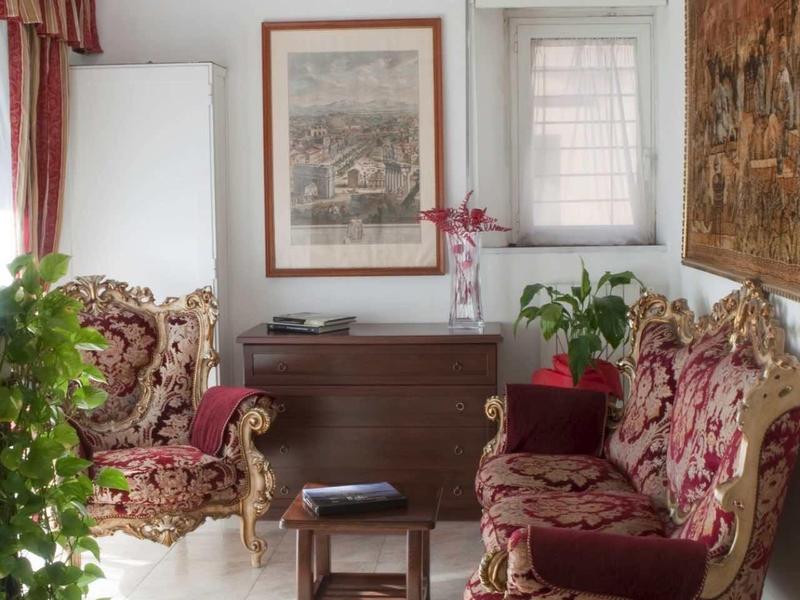 Elegantní posezení s vzorovanými křesly, dřevěným nábytkem a rostlinami v dobře osvětlené místnosti.