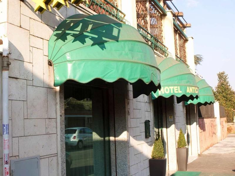 Fasáda hotelu s zelenými markýzami a cedulí se čtyřmi hvězdami.