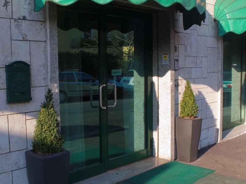 Vstup do hotelu Antico se zeleným markýzou a dvěma květináči.