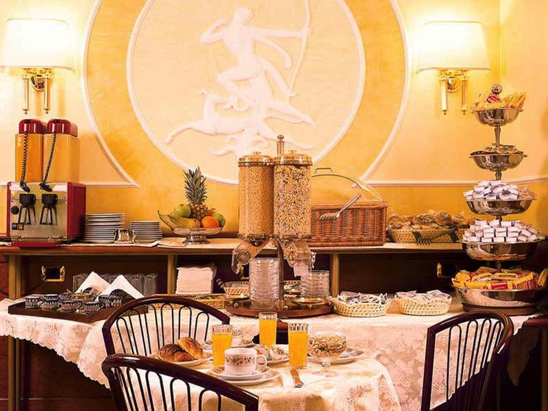 Stół śniadaniowy z bufetem, dozownikiem na płatki, sokiem i sztućcami w przytulnym pokoju.