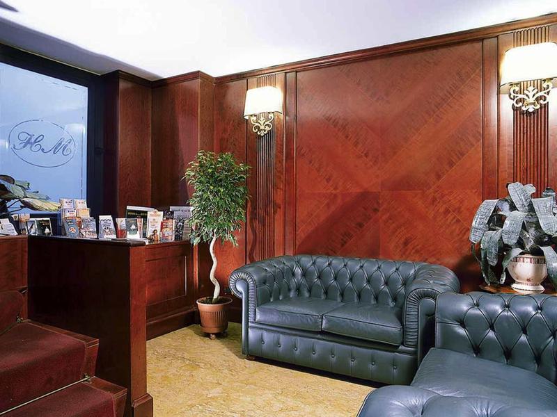 Elegancka poczekalnia z ciemnoniebieskimi skórzanymi sofami i drewnianymi ścianami w hotelu.