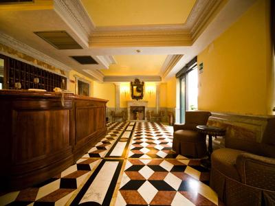 Eleganter Raum mit gemusterter Marmorfliesen, braunem Holztheke und bequemen Sofas.