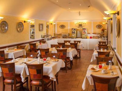 Przytulna jadalnia z białymi obrusami i drewnianymi meblami przy ciepłym świetle.