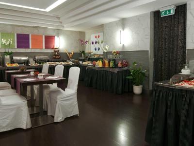 Vergaderruimte met gedekte tafels en gevarieerd buffet in een hotel.