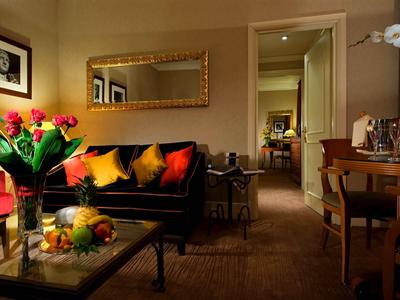 Gemütliches, elegant eingerichtetes Wohnzimmer mit Sofa, farbigen Kissen und einem Tisch mit Blumen und Obst.