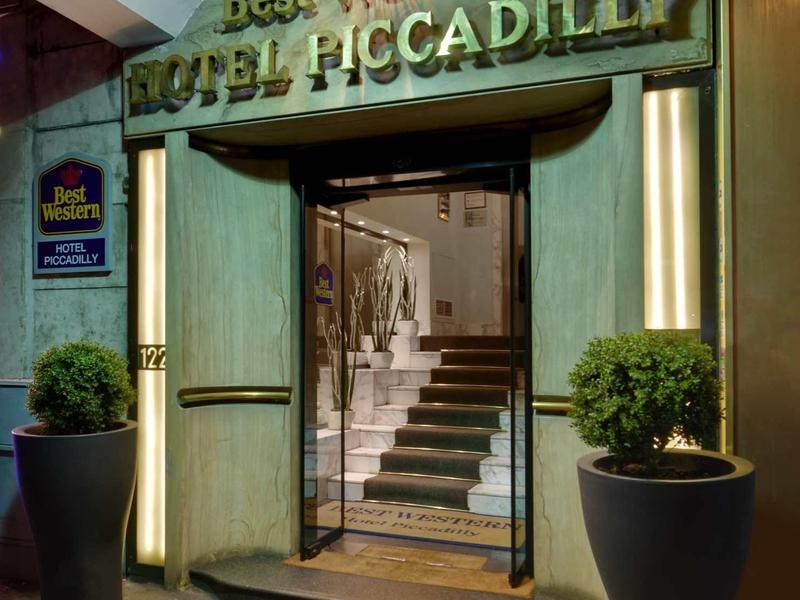 Wejście do hotelu Best Western Plus Piccadilly z klatką schodową i roślinami