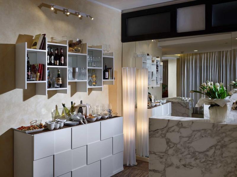 Nowoczesna przestrzeń hotelowa z marmurową recepcją i ozdobnymi półkami na ścianie.