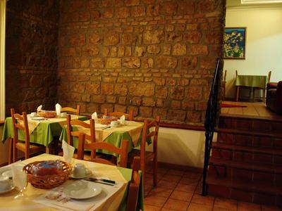 Acogedor comedor con mesas y sillas de madera y pared de piedra expuesta.