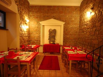 Restaurante acogedor con manteles rojos y paredes de piedra