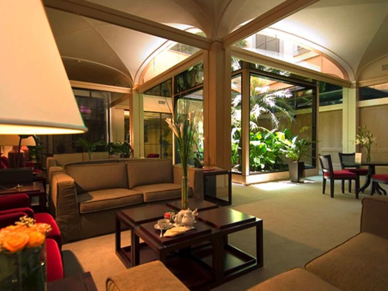 Elegantní, dobře osvětlený obývací pokoj s pohodlnými pohovkami a výhledem na zahradu