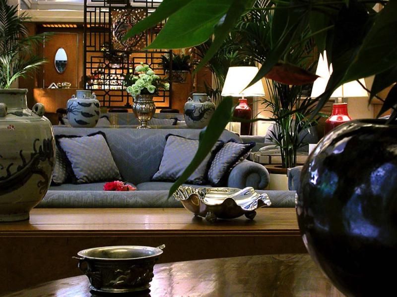 Pohodlný obývací pokoj s modrými pohovkami, rostlinami a dřevěnou výzdobou v hotelu