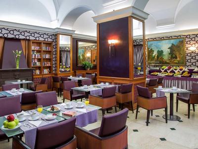 Eleganter Restaurantraum mit lila Stühlen, weißen Tischen und großen Wandgemälden.