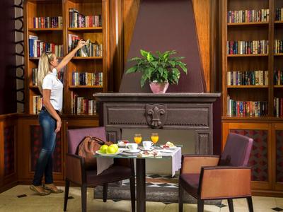 Cozy reading area with books, a table, and chairs in an elegant room.