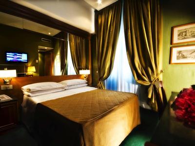 Gemütliches Hotelzimmer mit Doppelbett, Vorhängen und warmem Licht.