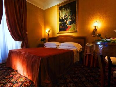 Cozy hotel room with double bed, warm lighting, and elegant decor.