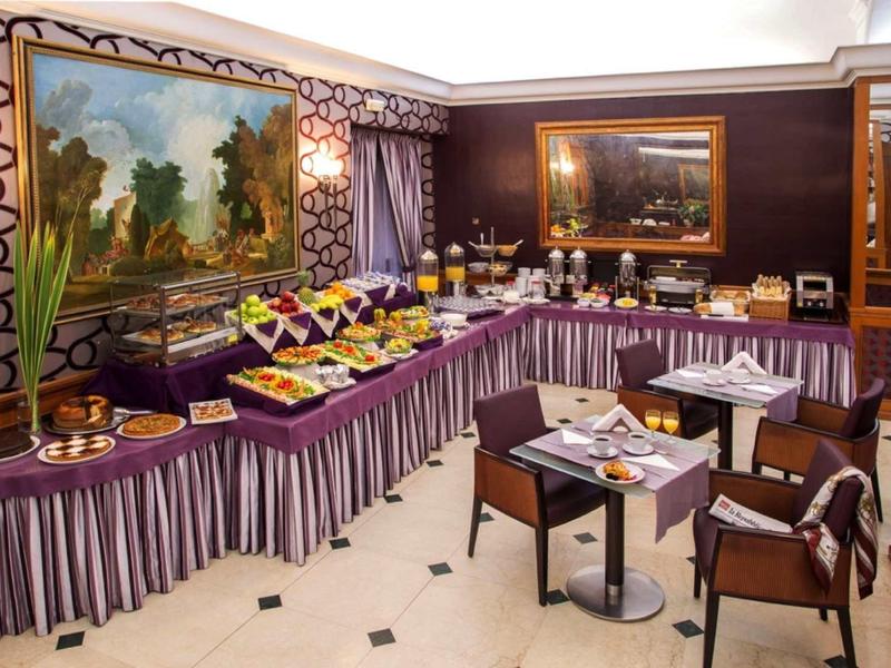 Elegant breakfast room with buffet, set tables, and ornate paintings on the walls.