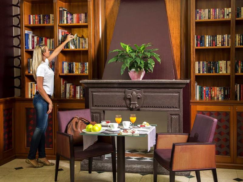 Cozy reading area with books, a table, and chairs in an elegant room.