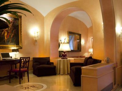 Espace de hall d'hôtel élégant avec arches, canapés, chaises et éclairage chaud.