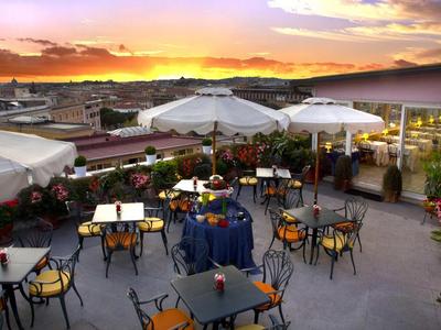 Terrasse sur le toit avec tables, chaises et parasols au coucher du soleil
