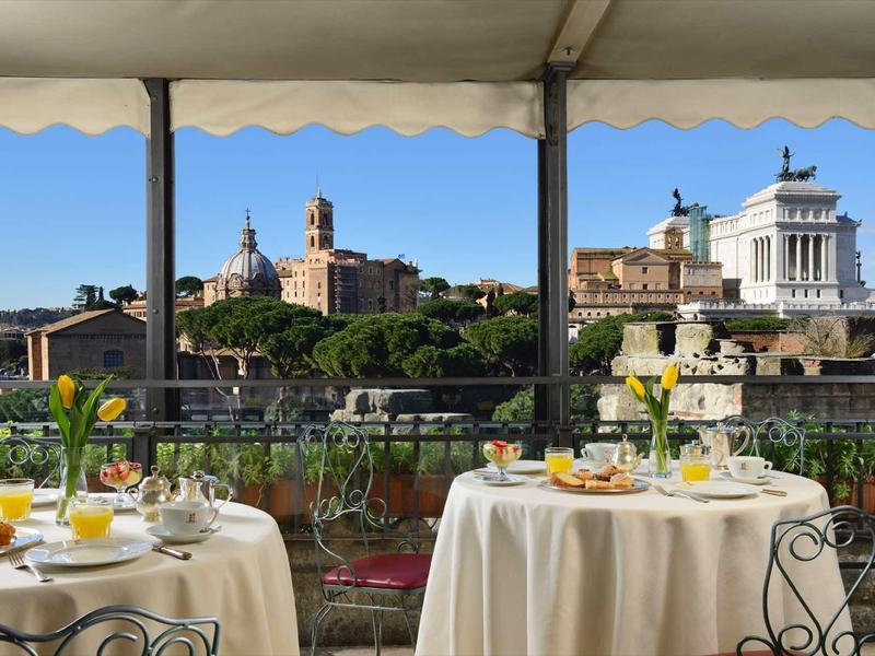 Widok z restauracji hotelowej z nakrytymi stołami na zabytkową panoramę miasta pod czystym niebem.