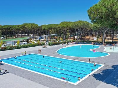 Piscine extérieure avec bassin rectangulaire et pataugeoire ronde dans une zone hôtelière ensoleillée