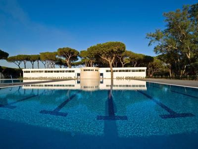 Piscine vide avec eau bleue claire et bancs sur le côté par temps ensoleillé.