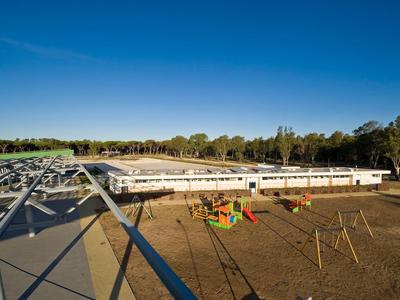 Grande zone de piscine avec chaises longues et aire de jeux sous un ciel clair