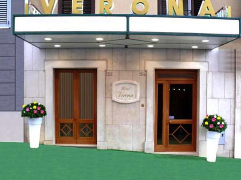 Hotel entrance with two doors and large flower pots on green flooring