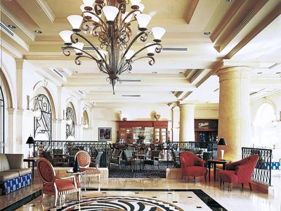 Elegante Hotellobby mit Kronleuchter, Säulen und kunstvoll gestaltetem Bodenmuster.