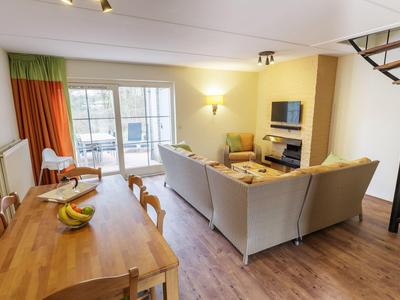 Moderner Wohnraum mit heller Sitzecke, Esstisch und Zugang zu Balkon.