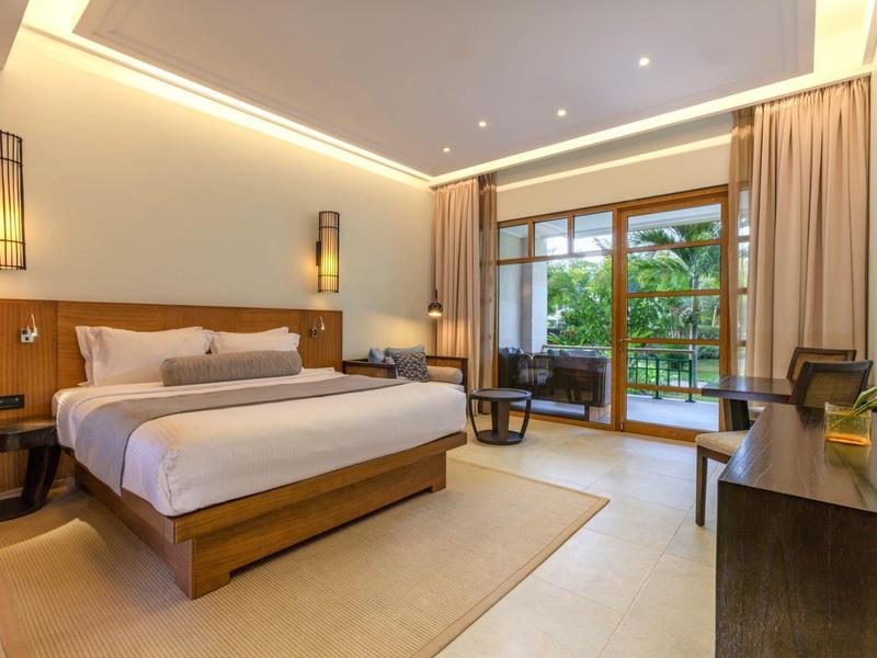 Modernes Schlafzimmer mit großem Bett, Holzmöbeln, bodentiefen Fenstern und Zugang zum Balkon.