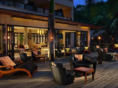 Gemütliche Hotelterrasse mit Stühlen und Tischen in der Abenddämmerung.