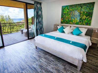 Camera d'hotel accogliente con letto matrimoniale e balcone con vista sul paesaggio verde.