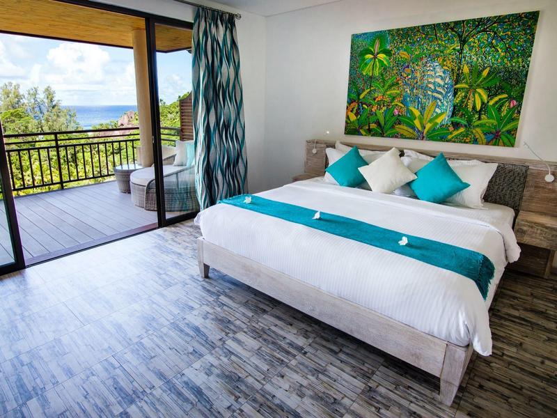 Camera d'hotel accogliente con letto matrimoniale e balcone con vista sul paesaggio verde.