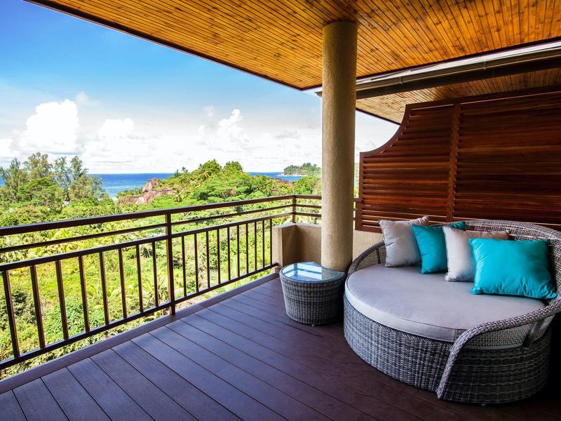 Accogliente balcone con divano rotondo che si affaccia su paesaggio verde e mare