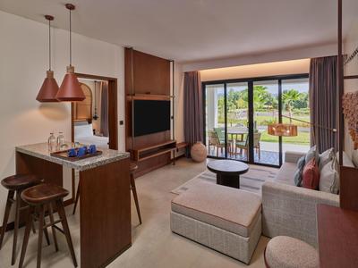 Modern eingerichtetes Wohnzimmer mit Sofas, TV und Zugang zu einem Balkon mit Aussicht.