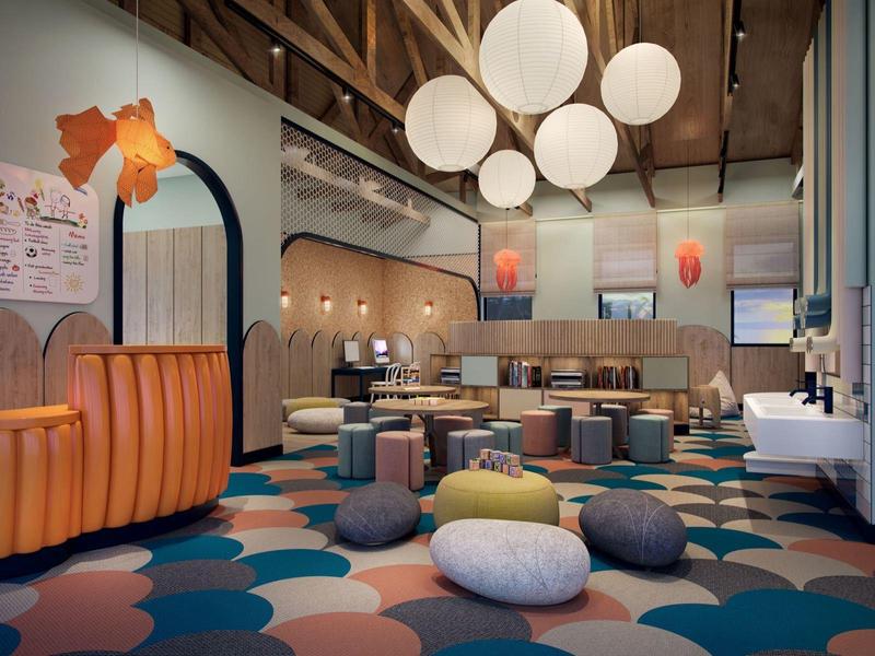 Modernes Café mit runden Deckenlampen, bunten Sitzkissen und warmen Holzakzenten.