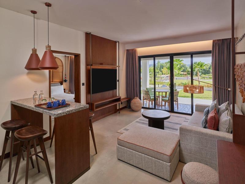 Modern eingerichtetes Wohnzimmer mit Sofas, TV und Zugang zu einem Balkon mit Aussicht.