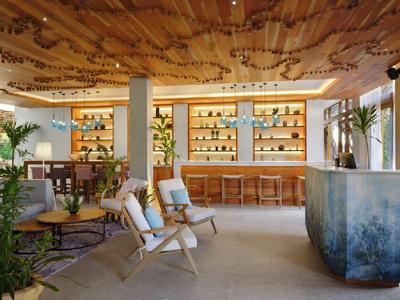 Příjemná hotelová hala s dřevěným stropem, barem, sezením a tlumeným osvětlením.