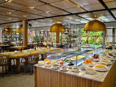 Moderní restaurace s prostřenými stoly a bufetem s pestrou nabídkou jídel.