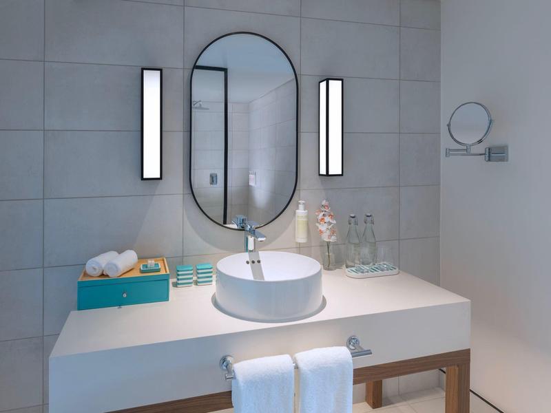 Modern bathroom vanity with oval mirror and lighting